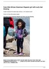 Cute little African American Hispanic girl with curly hair blowing